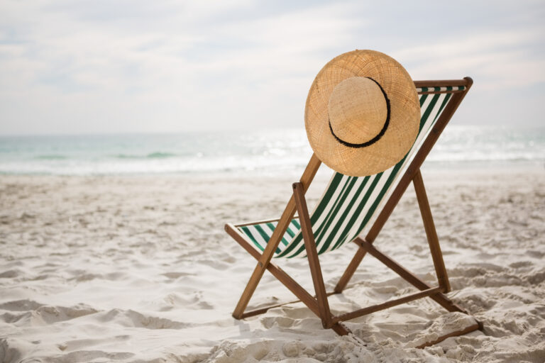 straw hat kept empty beach chair - Dynamik HR