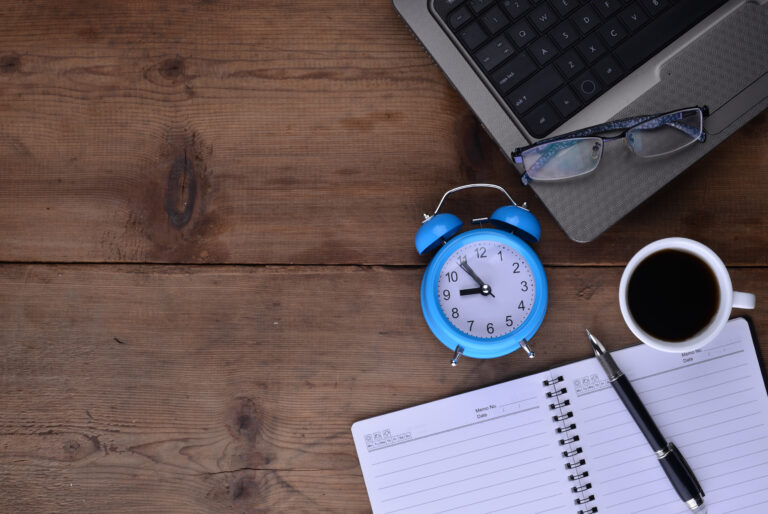 workplace with notebook clock coffee laptop - Dynamik HR